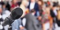 پس منظر میں سامعین کے ساتھ مائکروفون کی تصویر